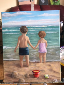 Girl and boy with red bucket on the shore