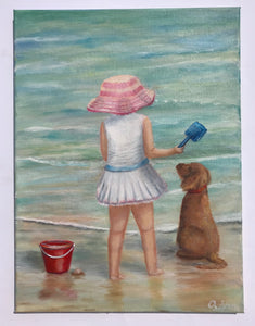 Girl and dog with red bucket on the shore